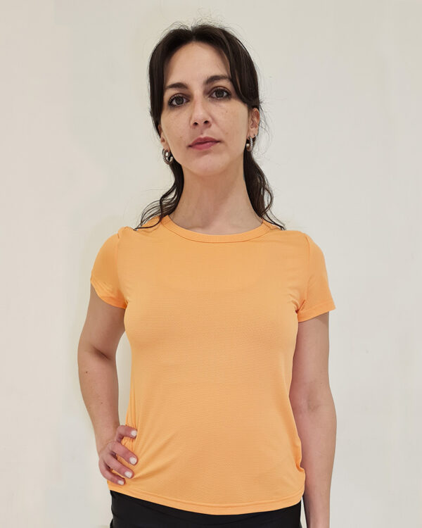 Mujer utilizando una polera manga corta Naranja con el logo de virtual Bike