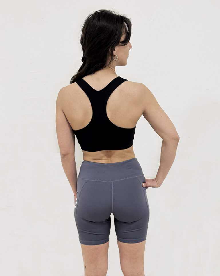 Mujer de espaldas utilizando una calza corta de color gris