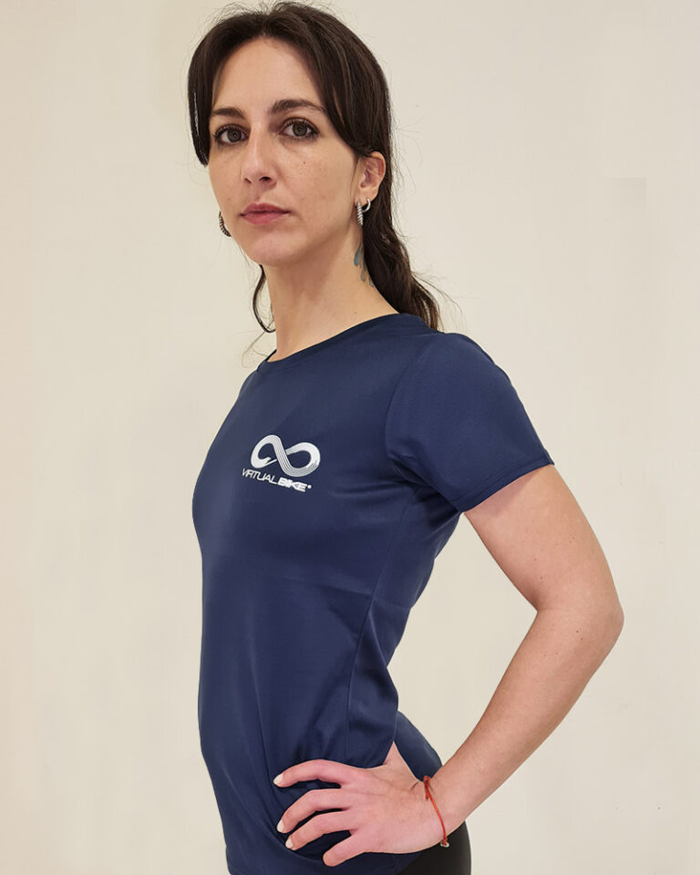 Mujer utilizando una polera manga corta azul en un perfil diagonal con el logo de virtual Bike