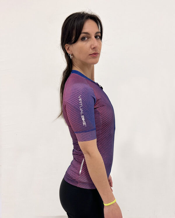 Mujer de perfil utilizando una polera manga corta de colores con el logo de Virtual Bike