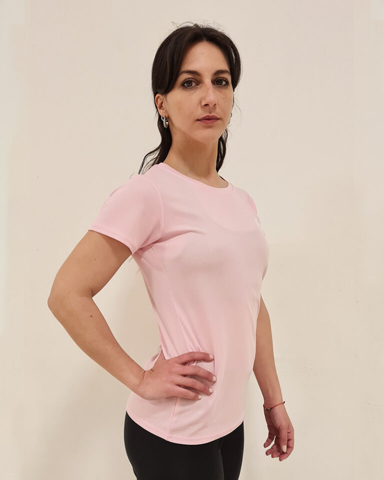 Mujer de perfil utilizando una polera manga corta de color rosa con el logo de Virtual Bike