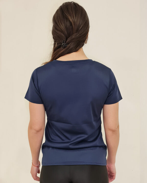 Mujer utilizando una polera manga corta azul de espaldas con el logo de Virtual Bike