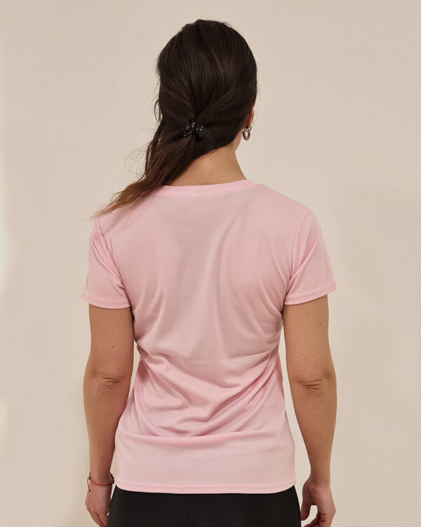 Mujer de espaldas utilizando una polera manga corta de color rosa con el logo de Virtual Bike