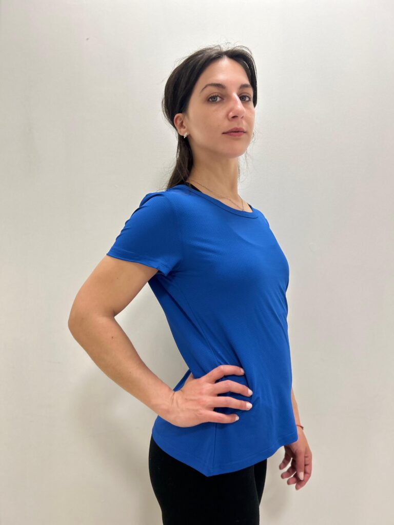 Mujer de perfil con una Polera Azul con el logo de Virtual Bike en la parte de atras