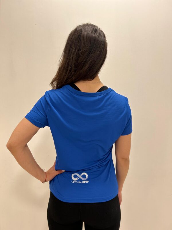 Mujer de espaldas con una Polera Azul con el logo de Virtual Bike en la parte de atras